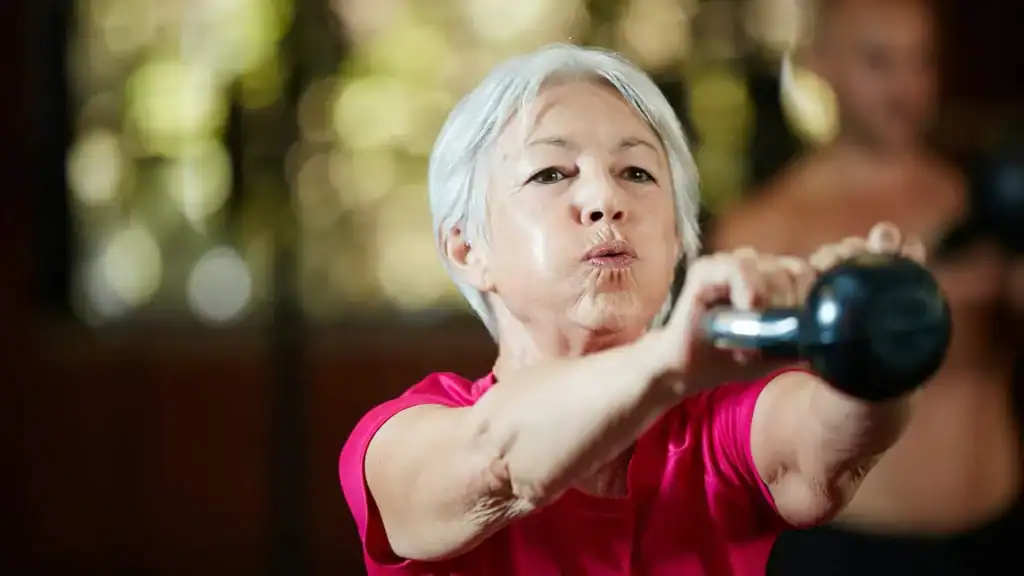Older woman doing weight training Hampshire to help her strength and longevity 