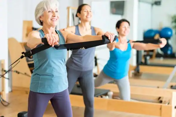 Toning Arms After 60: Empowering Womens Fitness Through Effective Weight Training 2 older woman doing weight training Hampshire and resistance in the gym to tone upper arms
